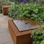 square water table in corten steel on garden patio